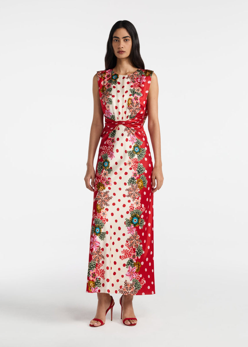 Woman wearing a floral and polka dot dress on a white background