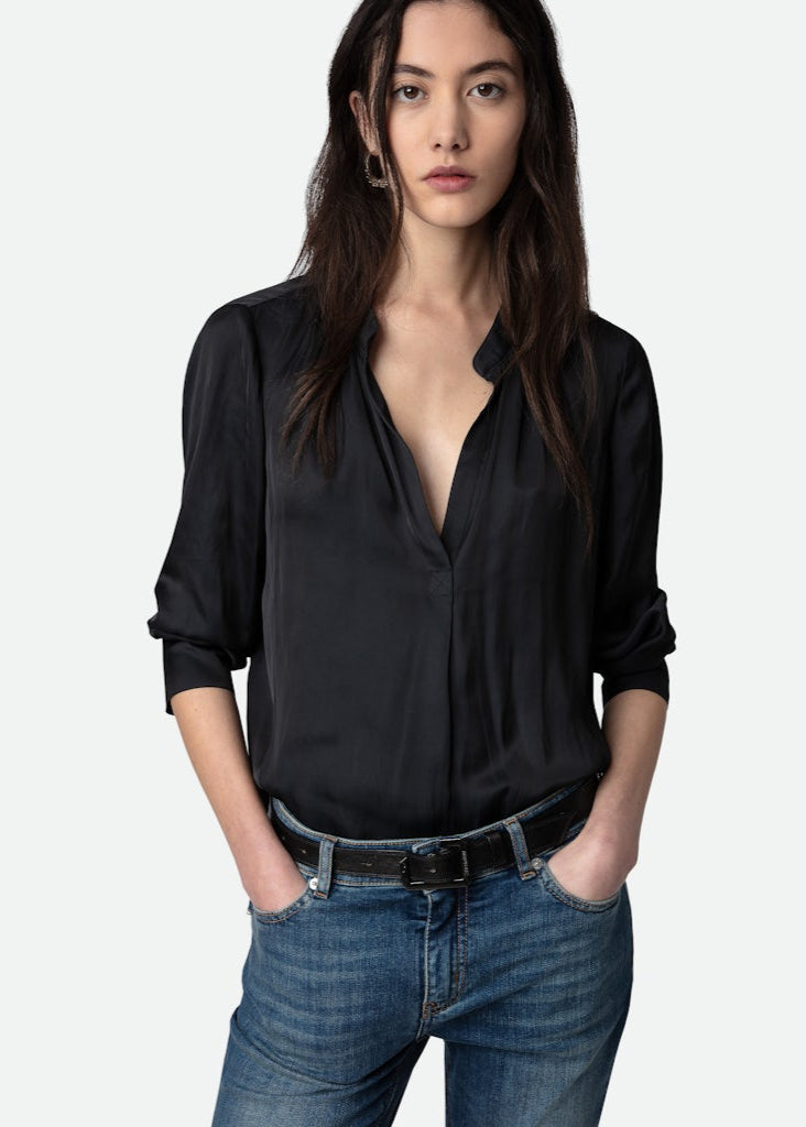 Woman wearing a black blouse and blue jeans on a white background
