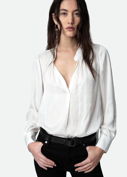 Woman wearing a white blouse with a deep neckline on a white background