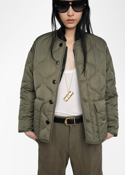 Person wearing a green quilted jacket on a white background